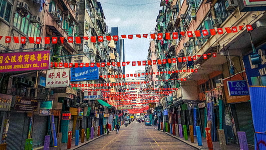 red pennants between concrete buildings at daytime thumbnail