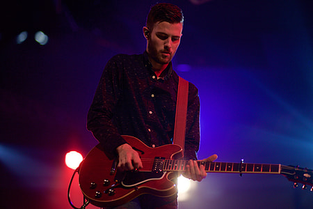 man in black dress shirt playing a guitar thumbnail