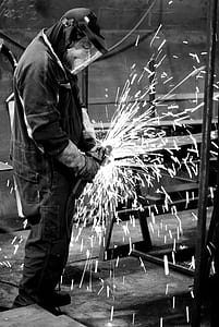greyscale photography of person using hand tool thumbnail