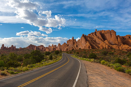 asphalt road near mountain under cloudy sky thumbnail