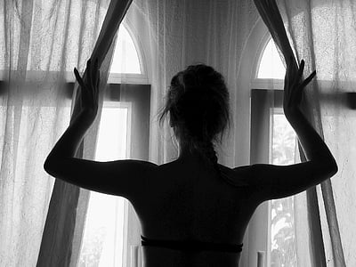 woman in black holding white sheer curtain thumbnail