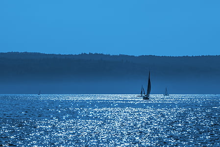 silhouette of sailboat under blue sky thumbnail