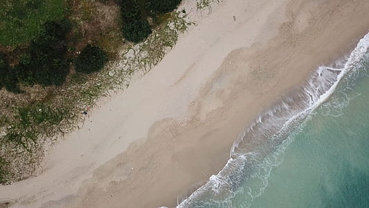 top view photography of ocean water and beach sand thumbnail