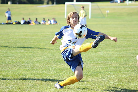 selective focus photography of boy kicking soccer ball thumbnail