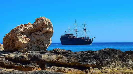 black galleon ship on a calm body of water thumbnail