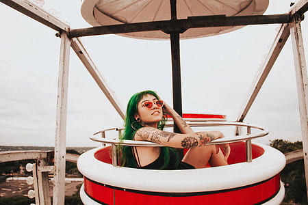 woman sitting on red and white ferris wheel taken at daytime thumbnail