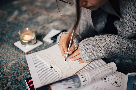 Woman in a grey sweater taking notes in an organizer thumbnail