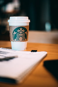 white Starbucks cup on brown wooden panel thumbnail