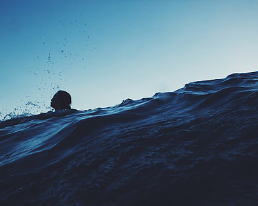 person swimming on body of water thumbnail