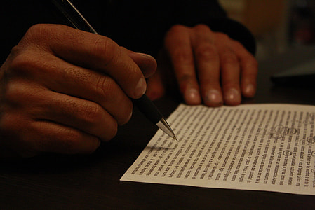 man in black long-sleeved shirt holding a black ballpoint pen thumbnail