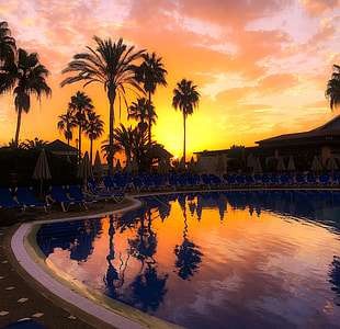 swimming pool under cloudy sky during sunset thumbnail
