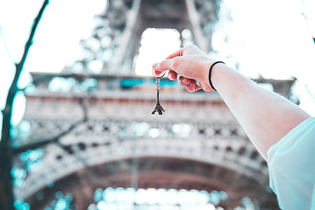 person holding Eiffel Tower key chain infront of Eiffel Tower thumbnail
