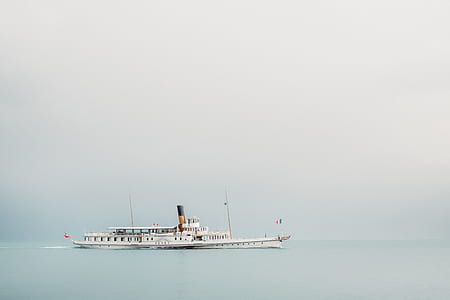 white boat in the middle of body of water thumbnail