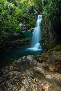 green trees and waterfall at daytime thumbnail