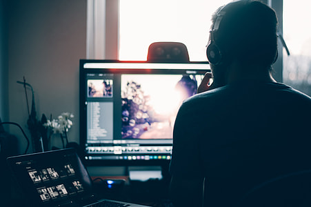 sitting man wearing headphones using computer thumbnail
