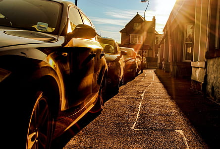 assorted-color-and-type vehicles park inlined beside buildings at daytime thumbnail