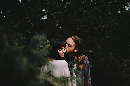 man kissing woman near trees thumbnail
