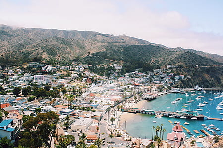 aerial view of mountains and village near body of water thumbnail