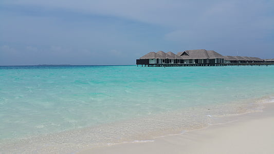 resort huts over sea nder blue sky thumbnail