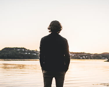Man Standing Facing Body of Water thumbnail