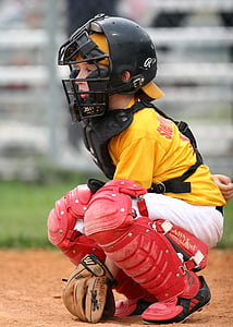 boy sitting while wearing baseball catcher item during daytime thumbnail