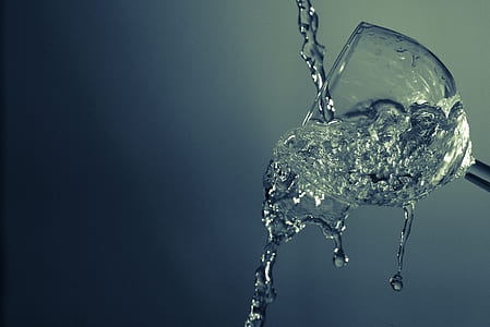 clear liquid pouring in tilted clear drinking glass thumbnail