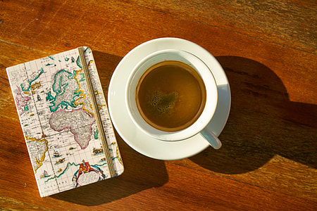 white ceramic cup filled with coffee on brown wooden surface thumbnail