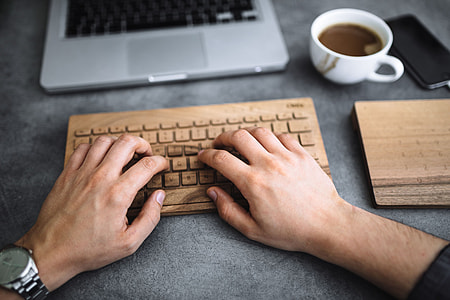 Young man typing on the wooden keyboard thumbnail
