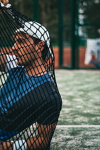 man leaning on black mesh net thumbnail