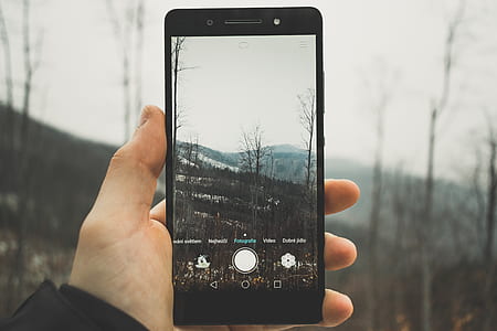 person using smartphone to take photo of landscape thumbnail
