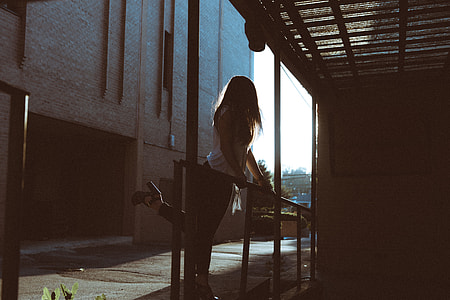 woman holding on handrail while lifting left foot thumbnail