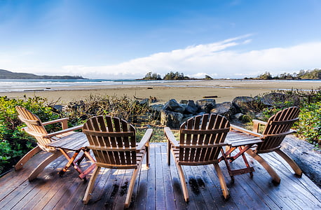 photo of four brown wooden adirondack chairs near bay during daytime thumbnail