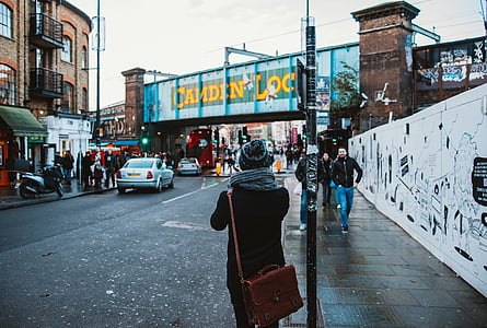 people standing and walking on street between buildings during daytime thumbnail
