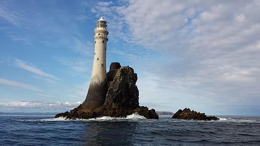 white lighthouse on body of water under white clouds during daytime thumbnail