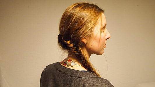 closeup photo of woman wearing gray top facing towards white wall thumbnail