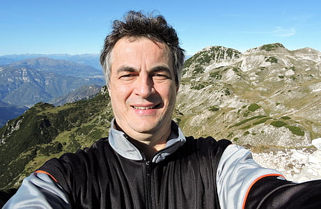 man taking selfie on top of mountain thumbnail