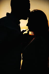 silhouette of couple holding ring during golden hour thumbnail