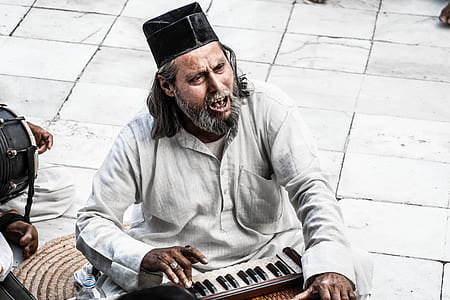 Man Sitting Holding Instrument thumbnail