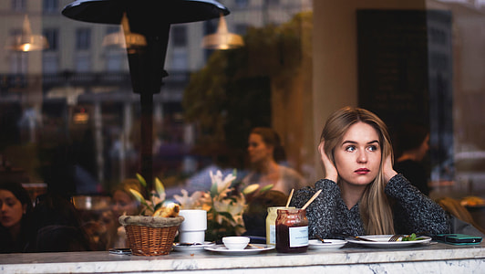 woman in grey sweater sitting in front of marble table covering her ears thumbnail