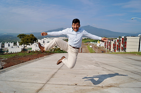 man jumping above of grey pavements thumbnail