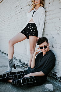 woman leaning on wall and man sitting on the floor thumbnail