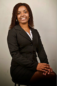 woman in black suit sitting near beige painted wall thumbnail