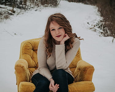 woman sitting on padded sofa chair while smiling thumbnail