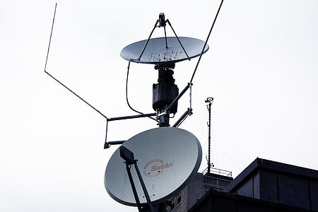 two gray parabolic antenna on wall of gray building thumbnail