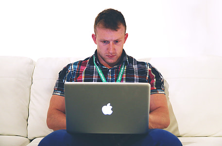 man using gray macBook on sofa thumbnail