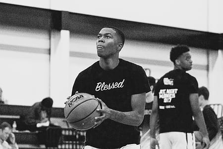 grayscale photography of person holding basketball thumbnail