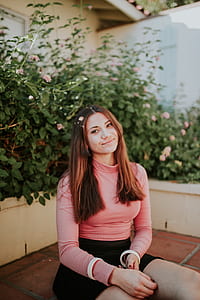 woman in pink sweatshirt sitting at the front of plants smiling thumbnail