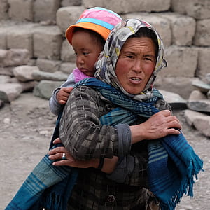 woman carrying girl during daytime thumbnail