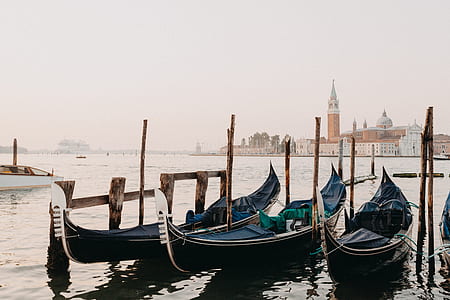 three black canoe boats on body of water during daytime thumbnail