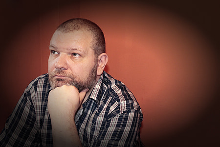 person sitting beside red wall thumbnail